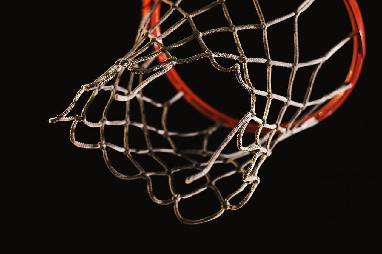A basketball hoop seen from below with a dark background